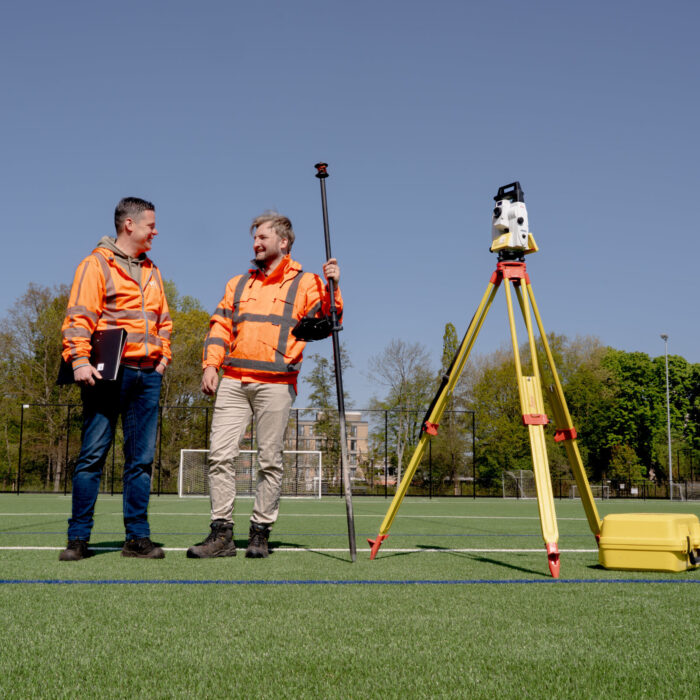 Uitvoerder Jan van der Salm en collega Martijn van Loon op het nieuwe kunstgrasveld.